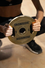 Athlète tenant un disque IRONSIDE chromé or au gym